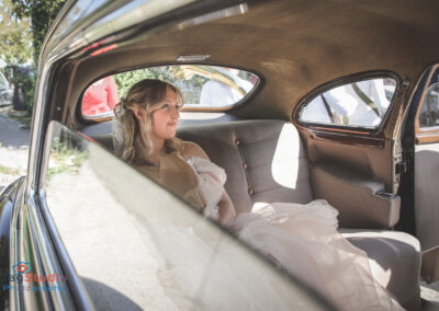 mlada na vencanju sedi u starom automobilu