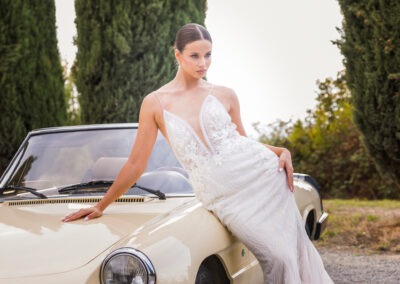 mlada pored starog modela automobila u italiji